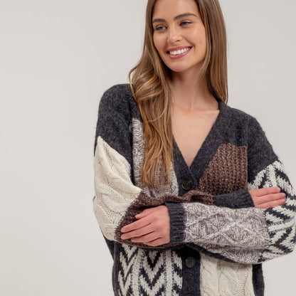 Woman wearing a patterned sweater and jeans on a plain background